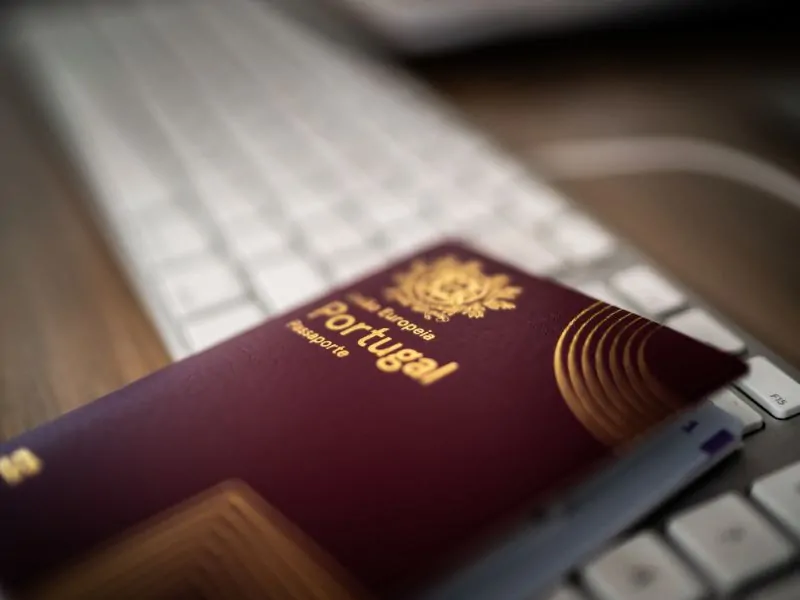 Portuguese passport on a keyboard – symbol of immigration and relocation to Portugal