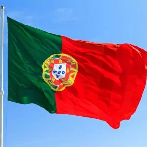 Portuguese flag waving against a clear sky – symbol of relocation to Portugal